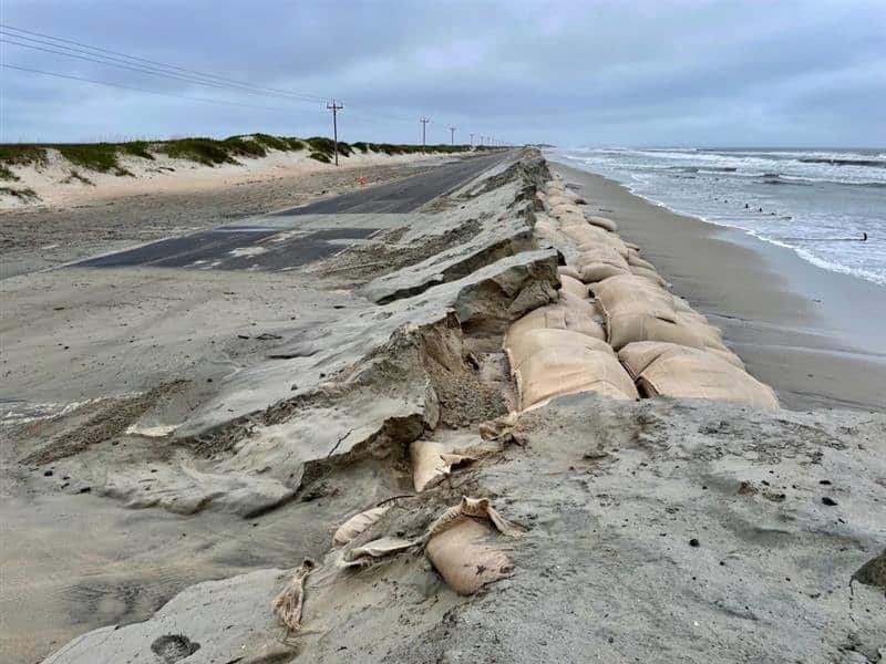 Sand and broken pavement cover NC Highway 12 at the sandbag dunes south of Ramp 59 after ocean overwash.