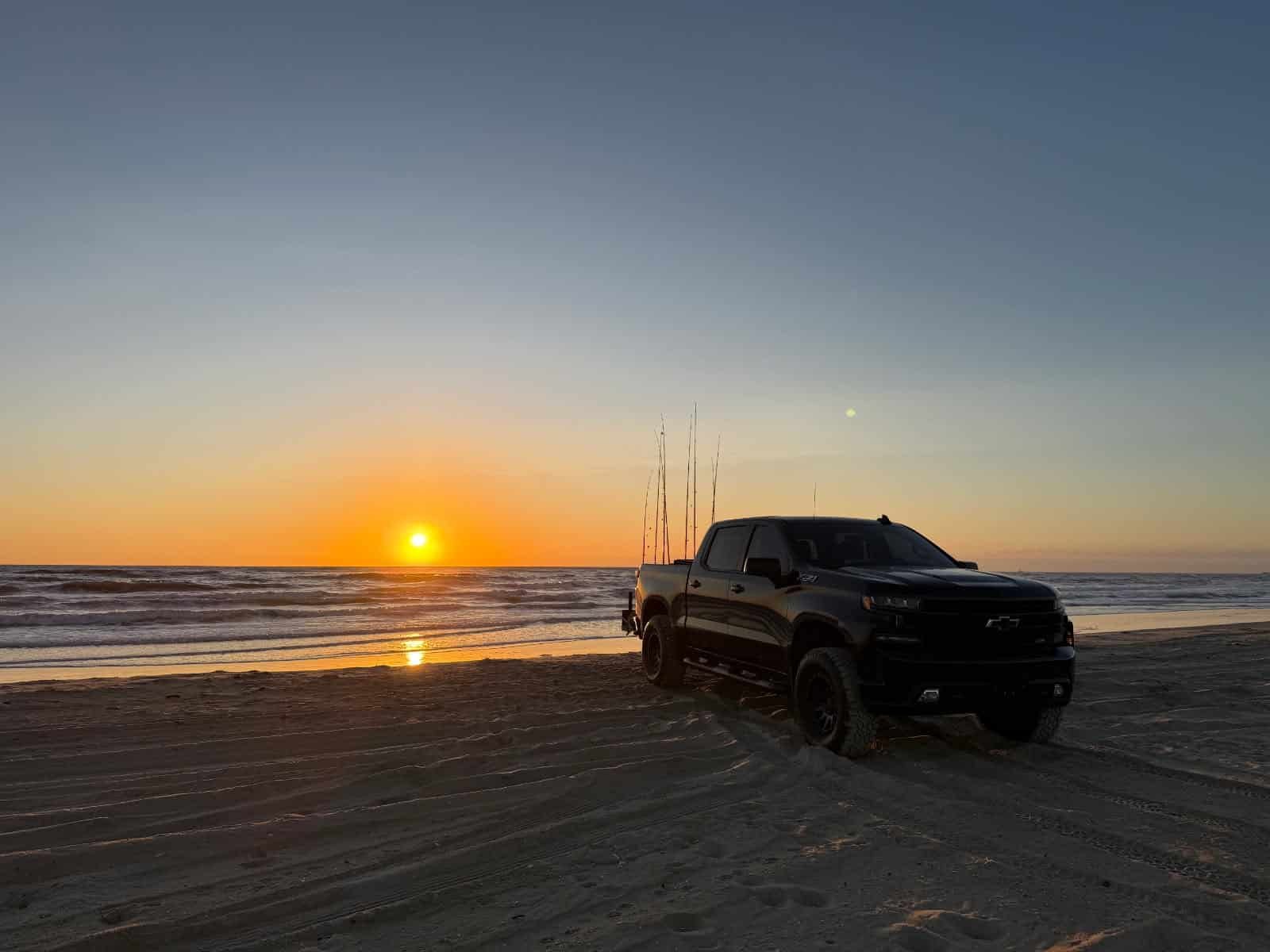 Sunrise beach driving on the Outer Banks, a 4x4 truck at the tide line