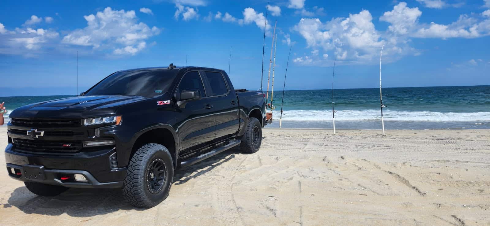 A Chevy Silverado Z71 on the sand with rod holders and the surf behind, Outer Banks